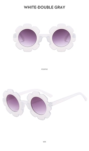 Detail view of white flower-shaped children's sunglasses with purple gradient lenses