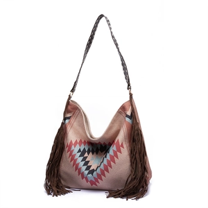 Detail of bohemian woven shoulder bag featuring geometric patterns and brown side tassels