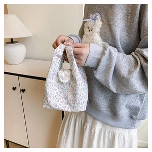 Close-up of floral knit handbag with pink flowers and delicate lace heart detail