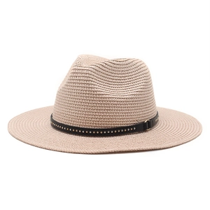 Detailed close-up of straw hat weave with black leather band and gold metal studs