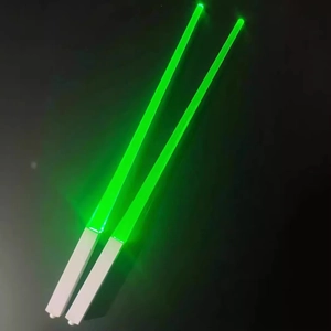 Pair of green LED glowing chopsticks with lightsaber design on a dark background