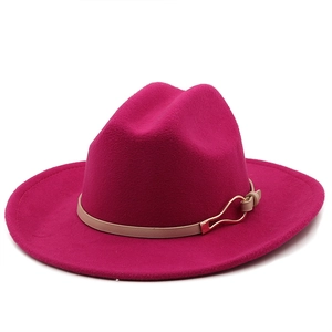 Detail view of rose red wool fedora hat with beige leather band and gold buckle