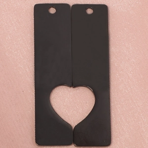 Macro view of black rectangular metal pendants with hollowed heart-shaped cutout