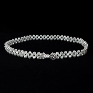 Detail of double-strand pearl waist chain featuring a sparkling rhinestone bow buckle