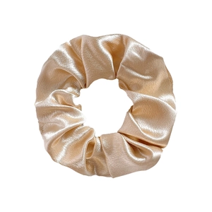 Detailed view of the smooth champagne gold satin scrunchie fabric and its lustrous texture