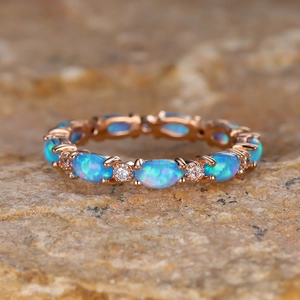 Macro view of vintage rose gold ring with blue opal clusters and zircon accents