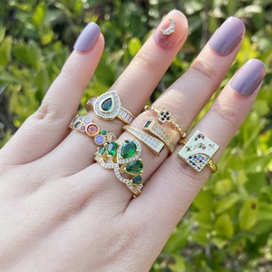 Detail showing stacked gold rings with colorful zircons and star moon designs