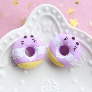 Detailed view of purple resin cat-faced donuts on a white porcelain relief plate
