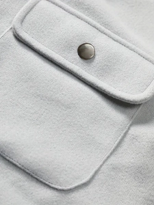 Macro view of light grey heavy flannel jacket pocket with flap and metal snap button