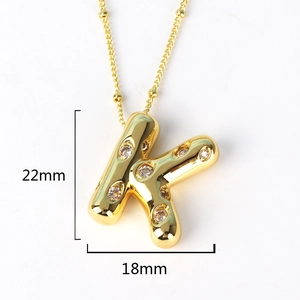Close-up of golden letter K pendant with rhinestones showing 22mm by 18mm dimensions