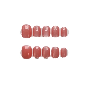 Coral pink press-on nails with shimmering cat-eye effect in a short round shape