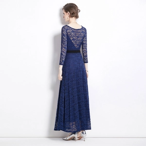 Elegante abito lungo in pizzo blu con ricami e maniche lunghe su uno sfondo bianco pulito