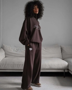 Détail de l'imprimé Le Club sur sweat à demi-zip marron et pantalon de jogging assorti
