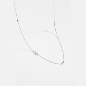 Detail view of silver letter N pendant with three embedded clear zircon gemstones