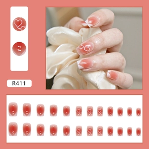 Unghie finte con sfumatura blush rossa, motivi a cuore bianchi e punte in stile francese