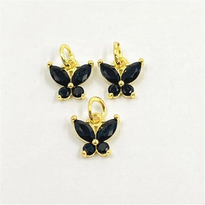 Vue détaillée de trois pendentifs papillon dorés avec zircons noirs micro-incrustés