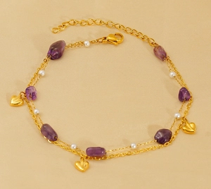Detail of double-layer gold anklet with purple stones, white pearls and heart charms