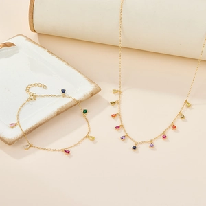 Detailed shot of gold plated necklace and bracelet set with multi-color teardrop stones