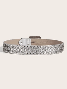 Détail d'une ceinture argentée avec strass et rivets rectangulaires sur base en cuir