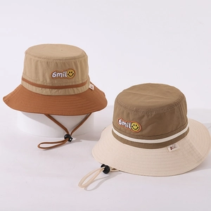 Close-up of color-blocked bucket hat with Smile embroidery and yellow smiley face icon