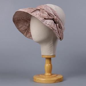 Detailed view of sun hat with textured fabric and large elegant bow on a mannequin