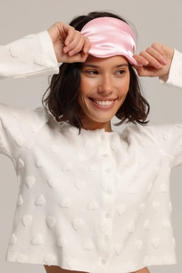 Détail du haut de pyjama jacquard à cœurs blancs avec boutons et masque rose