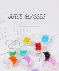 Détail de mini breloques cocktail avec gobelets rayés et porte-clés sur fond texturé