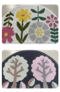 Detail of semi-circle bathroom mats featuring soft floral and tree patterns in plush velvet