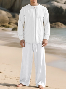 Détail d'un ensemble homme en coton blanc avec pantalon à cordon et chemise sur la plage