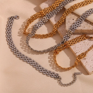 Close-up of gold and silver watchband style chain necklaces with 18K engraved tags