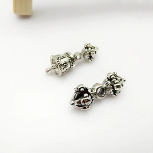 Macro detail of retro silver Vajra Bell and Phurba pendants for Buddhist jewelry DIY