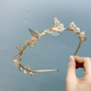 Close-up of golden hollow 3D alloy butterfly details on a minimalist headband