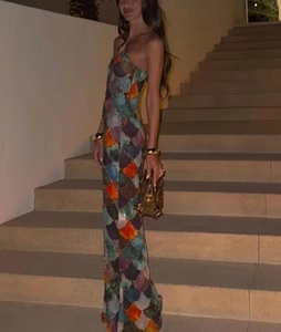 Detail of mermaid print halter dress with colorful scale pattern worn by model on stairs