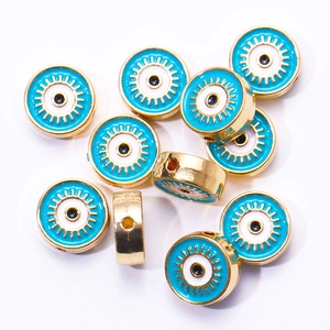 Détail de perles œil porte-bonheur dorées avec motifs bleus pour création de bijoux