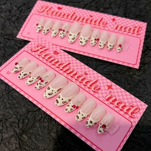 Handmade leopard print press-on nails with 3D cherry accents on pink checkerboard cards