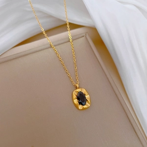 Gold plated titanium steel necklace with irregular texture and black gemstone pendant