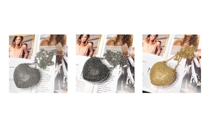 Three heart-shaped rhinestone evening bags in silver, gunmetal, and gold with chain straps