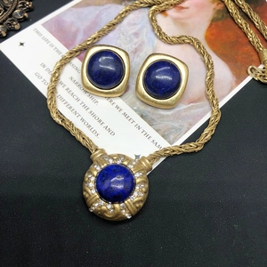 Detail of vintage gold-plated necklace and earrings set with lapis lazuli and crystals