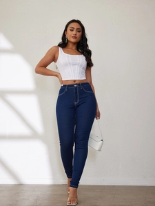 Detail of dark blue skinny jeans with white contrast stitching and white corset top