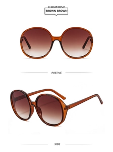 Detail view of round oversized amber resin sunglasses with gradient brown lenses