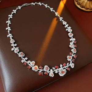 Detailed shot of vintage silver floral necklace with red gemstones on leather