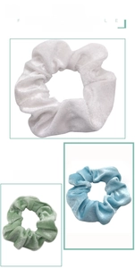 Detail of velvet scrunchies in white, light blue, and green with soft plush texture