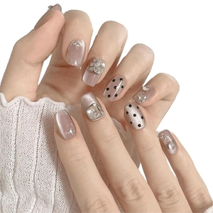 Faux ongles courts œil-de-chat mauves avec pois noirs et accents de strass argentés