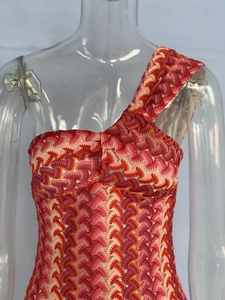Close-up of multicolor crochet zigzag texture on a one-shoulder knit beach dress