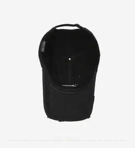 Internal detail of washed black cotton baseball cap showing 100% cotton label and stitching