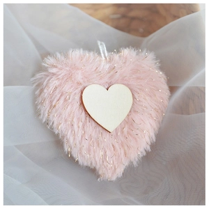 Close-up of pink fuzzy plush heart ornament with gold glitter and small wood heart charm