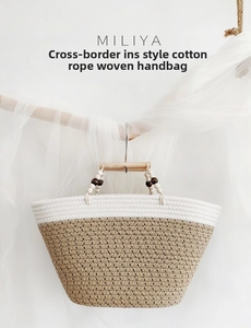 Detailed close-up of woven cotton rope bag with beaded wooden handle and bicolor design