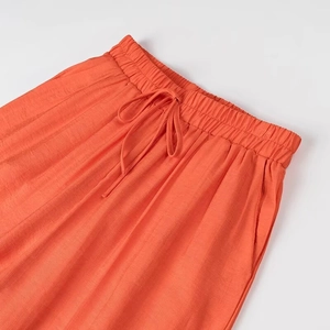 Détail du pantalon orange avec taille élastique et cordon de serrage ajustable