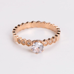 Detail of rose gold honeycomb ring with central round stone and paved diamonds