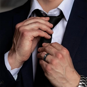 Men's black stainless steel ring with white cross pattern on male model wearing a suit